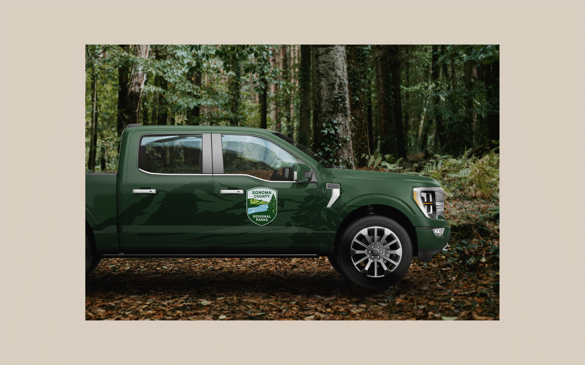 green pickup truck in a forest with the Sonoma County Regional Parks logo on the side of it